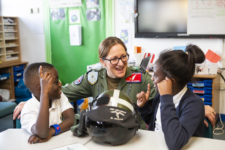 Uniformed pilot talking with school children