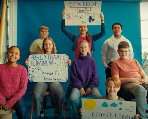Group of Icelandic children hold up signs inviting volunteers