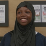 Junior aged girl with a huge smile, wearing a hijab