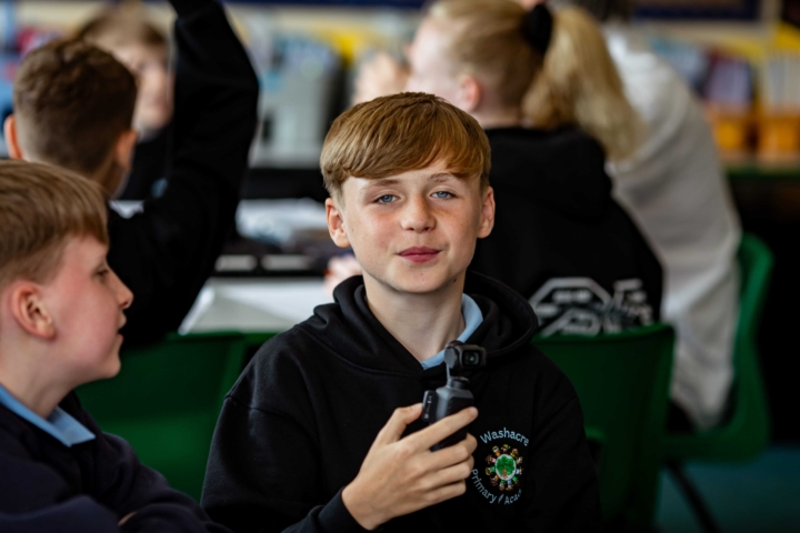 Primary school pupil engages with media equipment as part of a visit from Inspiring the Future workplace volunteers working in local media.